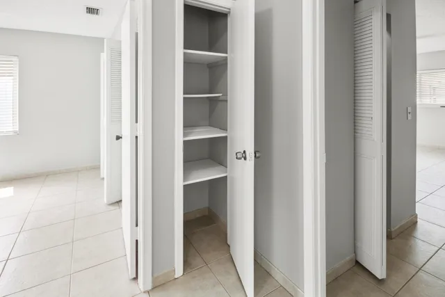 a view of a hallway with closet and a window