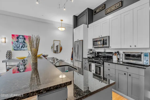 a kitchen with stainless steel appliances granite countertop a sink stove and microwave