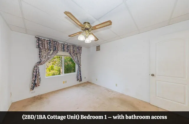 a view of a hallway with wooden floor and a bathroom