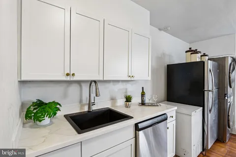 a kitchen with stainless steel appliances white cabinets and a refrigerator