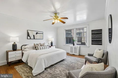 a bedroom with furniture and a large window
