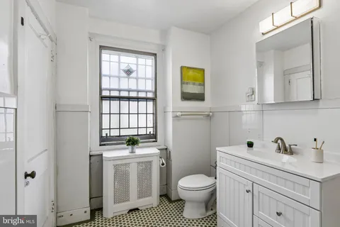 a bathroom with a sink a toilet and a window