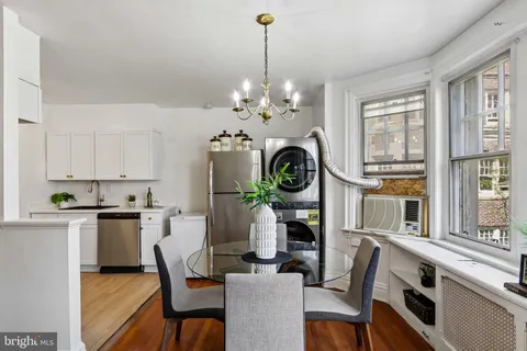 a dining room with furniture a chandelier and wooden floor