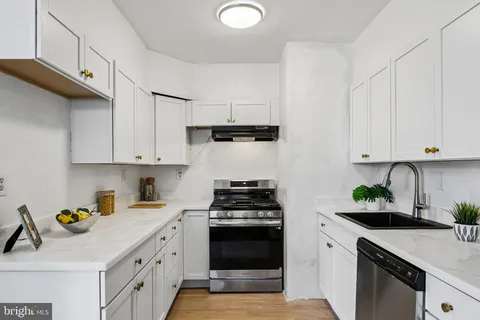 a kitchen with cabinets a stove and a kitchen island