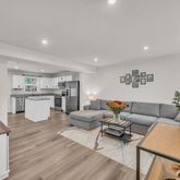 a living room with furniture and kitchen view