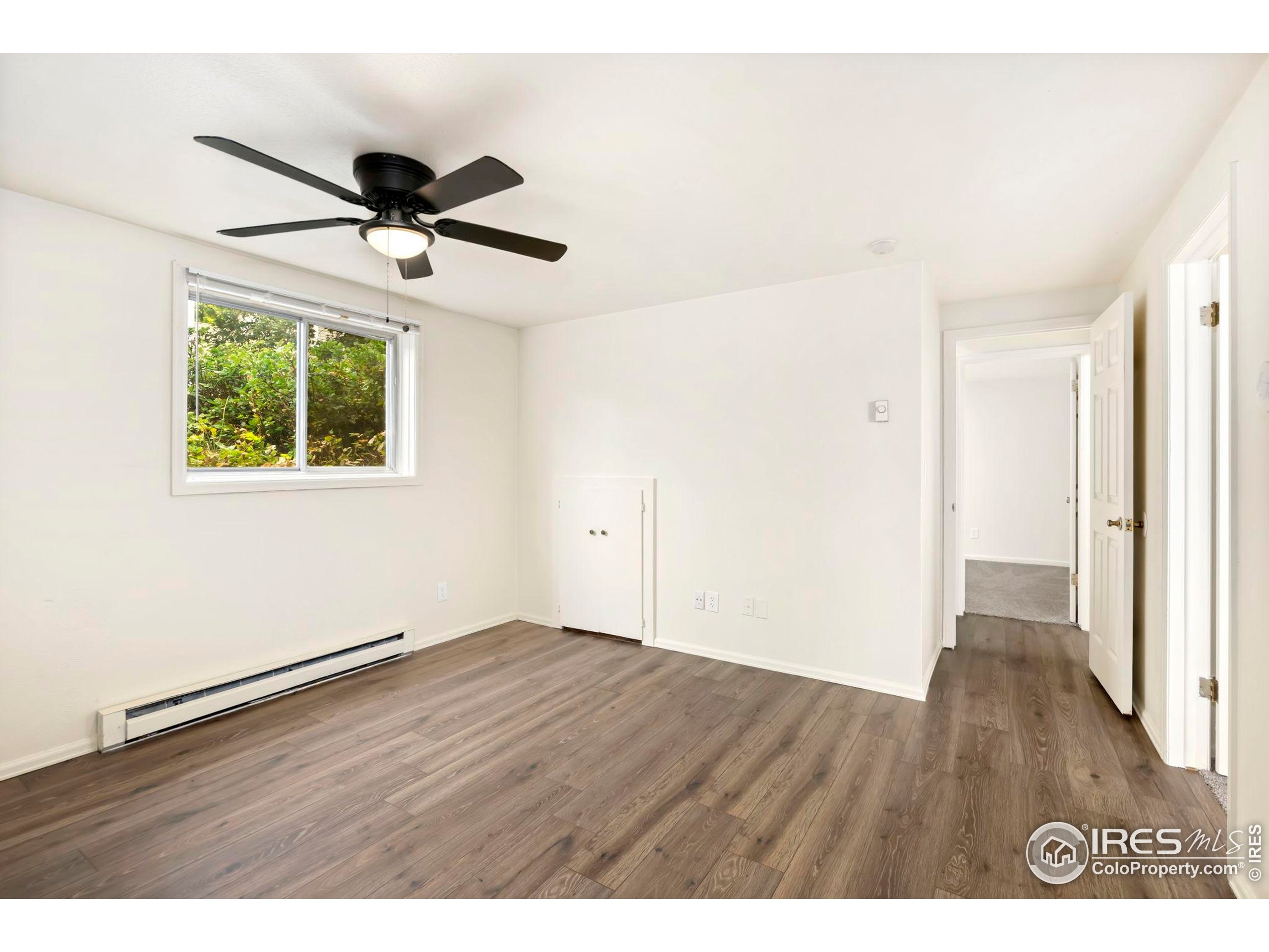 2828 Silverplume Drive, Unit R3 Fort Collins, CO 80526 - Photo 14 of 44 a view of an empty room with wooden floor and a ceiling fan