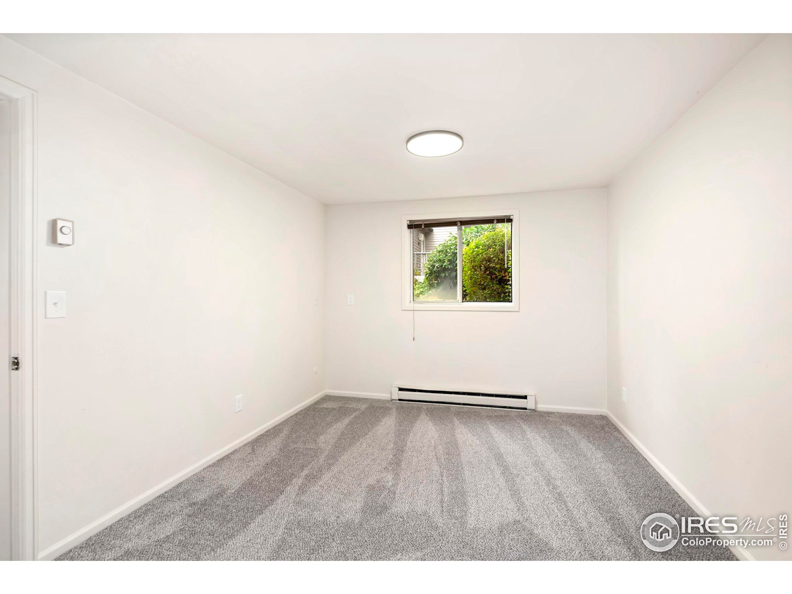 2828 Silverplume Drive, Unit R3 Fort Collins, CO 80526 - Photo 22 of 44 a view of an empty room with wooden floor and a window