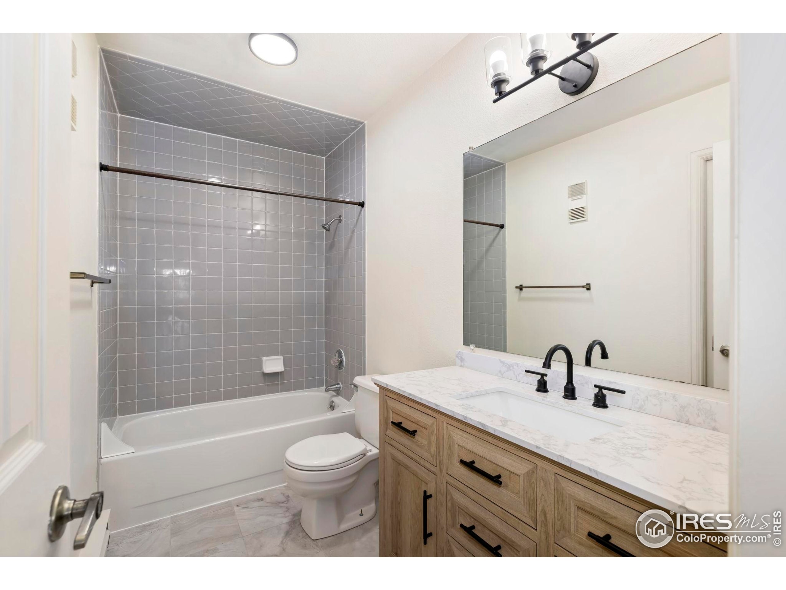 2828 Silverplume Drive, Unit R3 Fort Collins, CO 80526 - Photo 25 of 44 a bathroom with a granite countertop sink a toilet a mirror a bathtub and shower