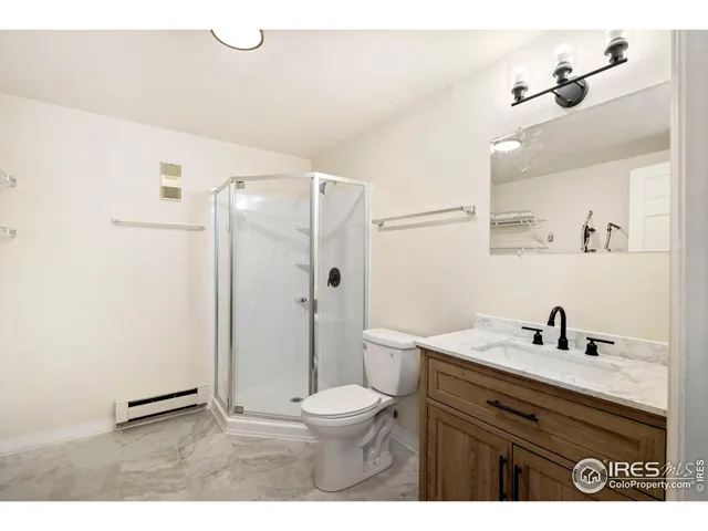 a bathroom with a sink a toilet a mirror and shower