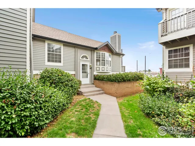 a front view of a house with a yard and potted plants