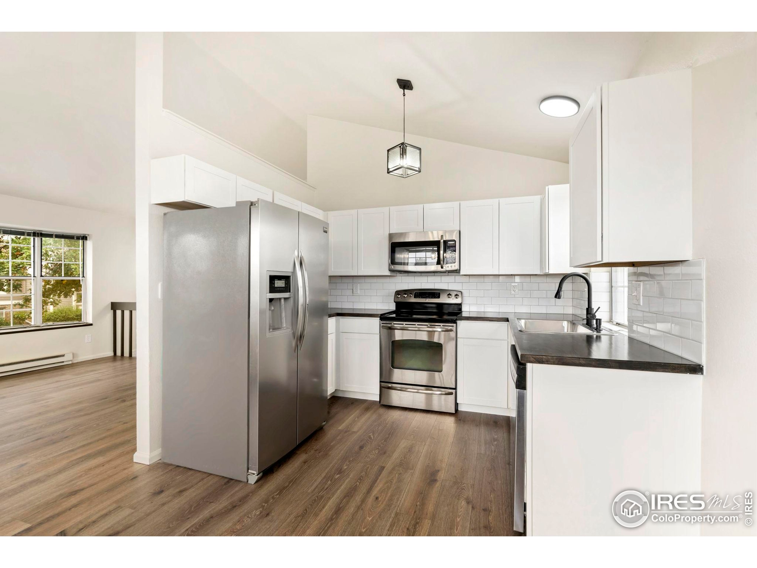 2828 Silverplume Drive, Unit R3 Fort Collins, CO 80526 - Photo 7 of 44 a kitchen with stainless steel appliances kitchen island a refrigerator sink and cabinets