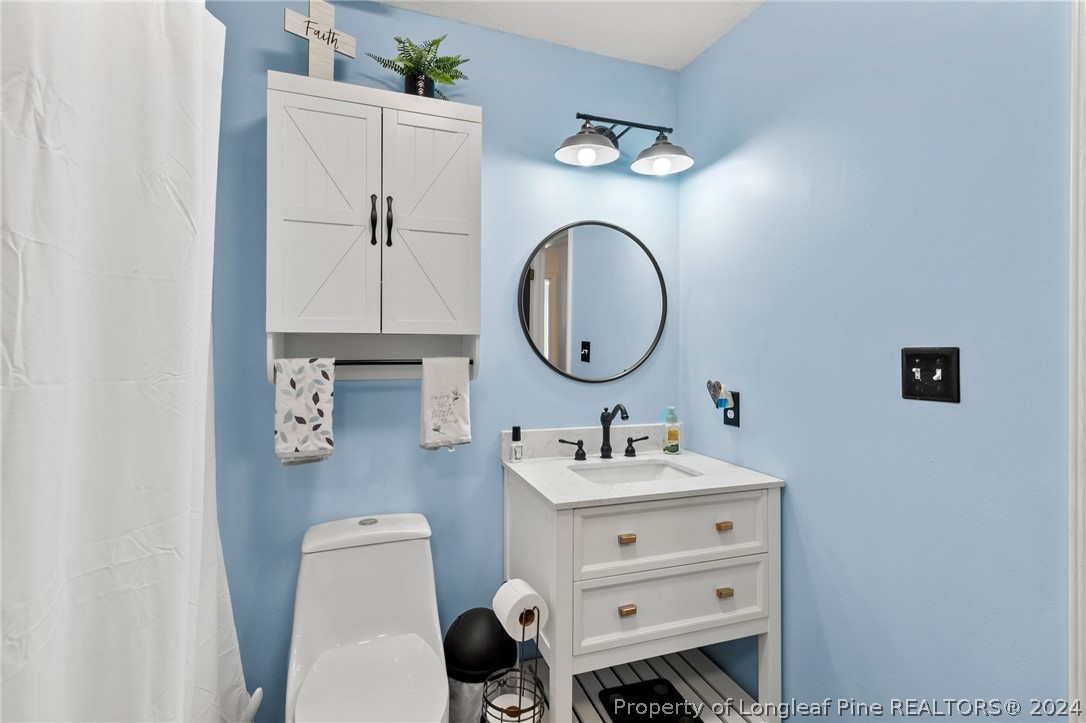 5334 Tory Hill Road Hope Mills, NC 28348 - Photo 14 of 27 a bathroom with a double vanity sink mirror and toilet