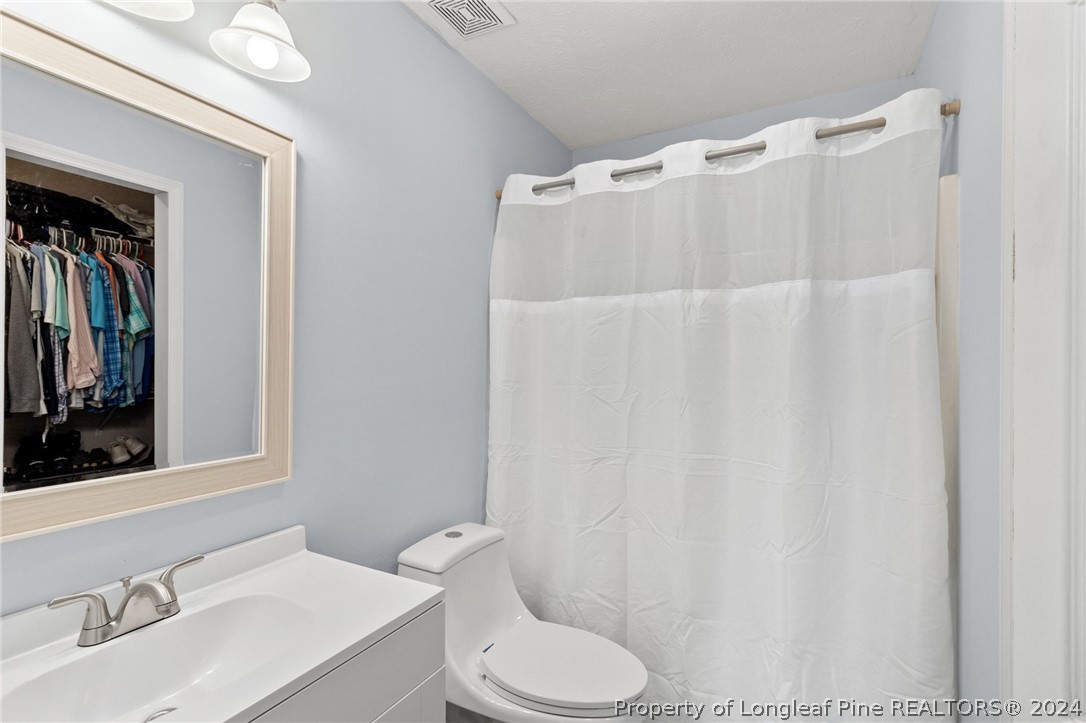 5334 Tory Hill Road Hope Mills, NC 28348 - Photo 20 of 27 a white toilet sitting next to a bathroom sink