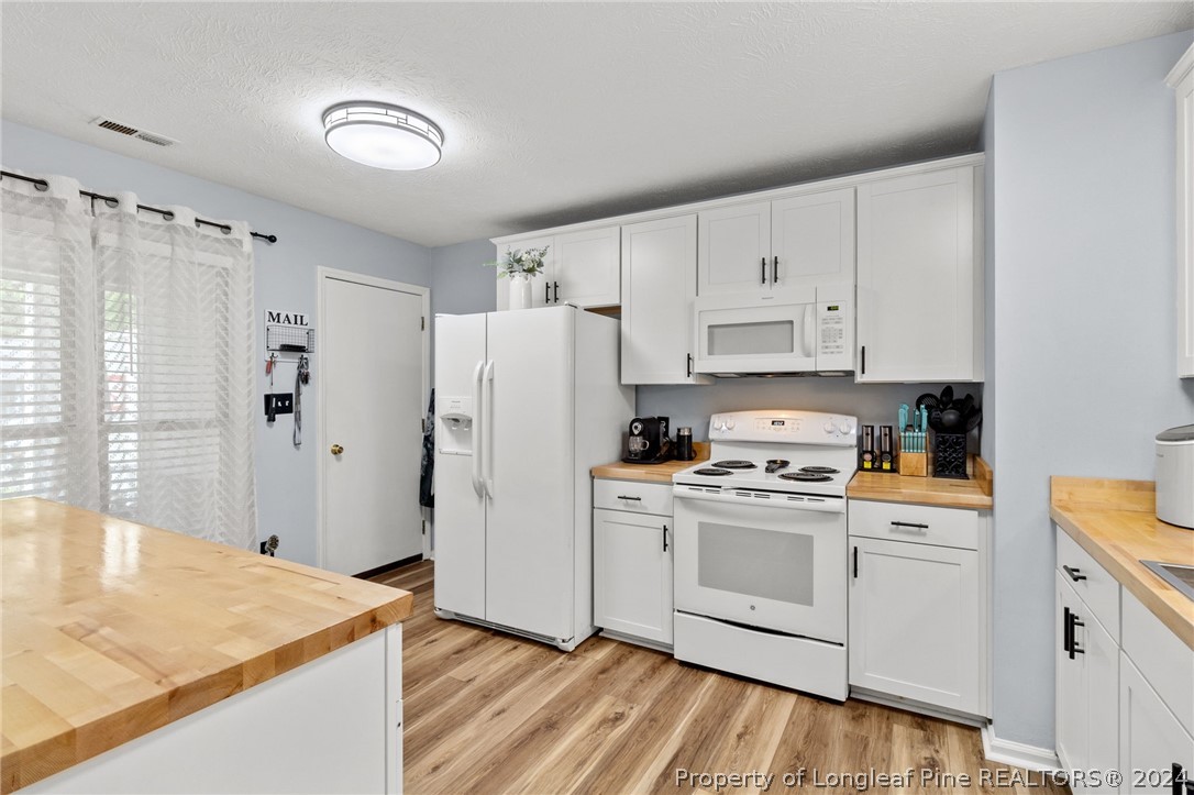 5334 Tory Hill Road Hope Mills, NC 28348 - Photo 6 of 27 a kitchen with white cabinets and white appliances