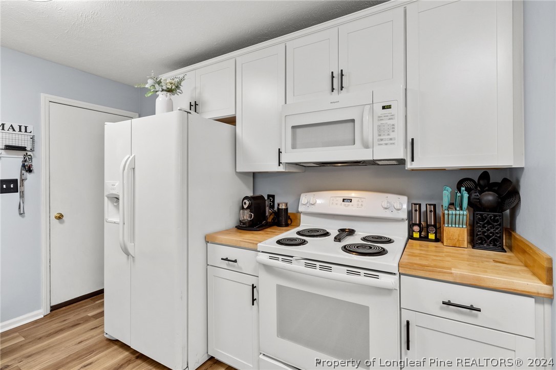 5334 Tory Hill Road Hope Mills, NC 28348 - Photo 7 of 27 a kitchen with white cabinets and white appliances