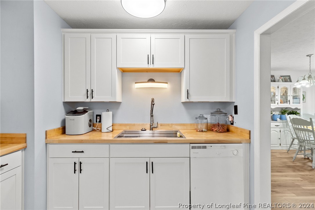 5334 Tory Hill Road Hope Mills, NC 28348 - Photo 9 of 27 a kitchen with stainless steel appliances granite countertop white cabinets and a sink
