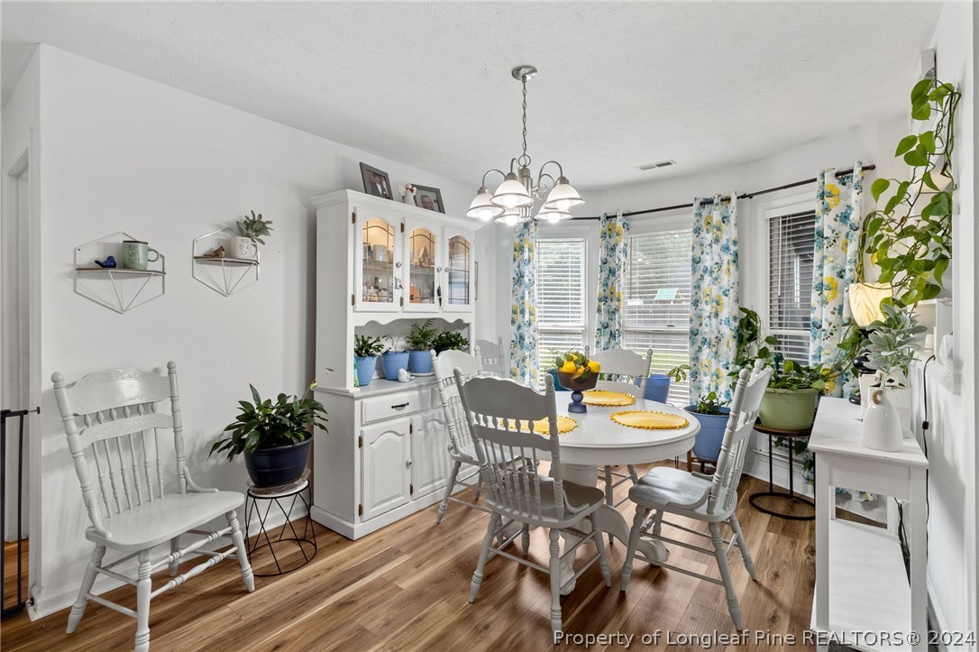 5334 Tory Hill Road Hope Mills, NC 28348 - Photo 10 of 27 a dining room with furniture a chandelier and wooden floor