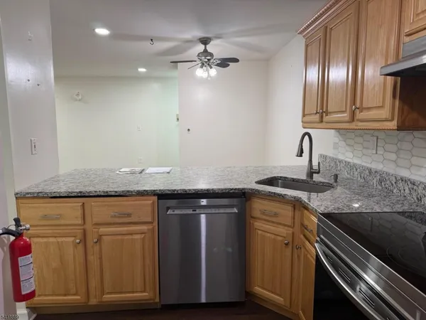 a kitchen with granite countertop a sink and cabinets