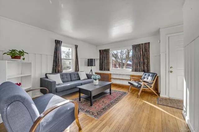 a living room with furniture a rug and a large window