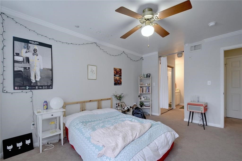 501 West 26th Street, Unit 121 Austin, TX 78705 - Photo 5 of 12 a spacious bedroom with a bed a couch and a chandelier