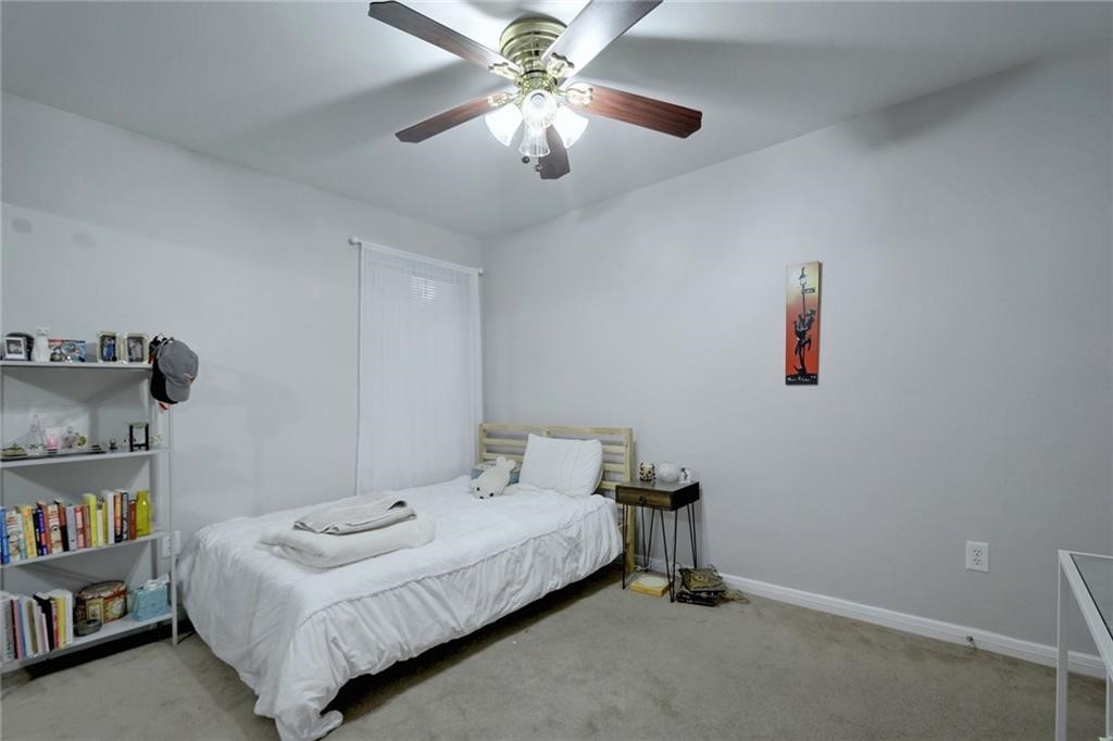 501 West 26th Street, Unit 121 Austin, TX 78705 - Photo 7 of 12 a bedroom with a bed and a chandelier
