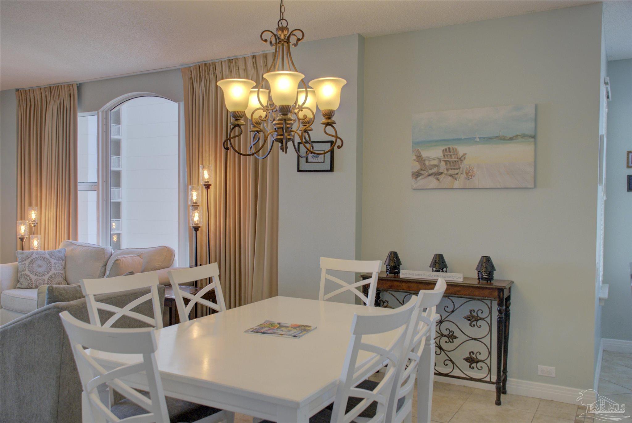 8501 Gulf Boulevard, Unit 10F Navarre, FL 32566 - Photo 13 of 35 a view of a dining room with furniture and chandelier