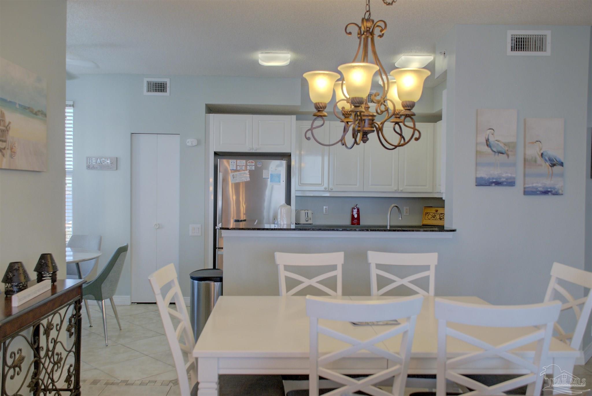8501 Gulf Boulevard, Unit 10F Navarre, FL 32566 - Photo 14 of 35 a view of a dining room with furniture and chandelier