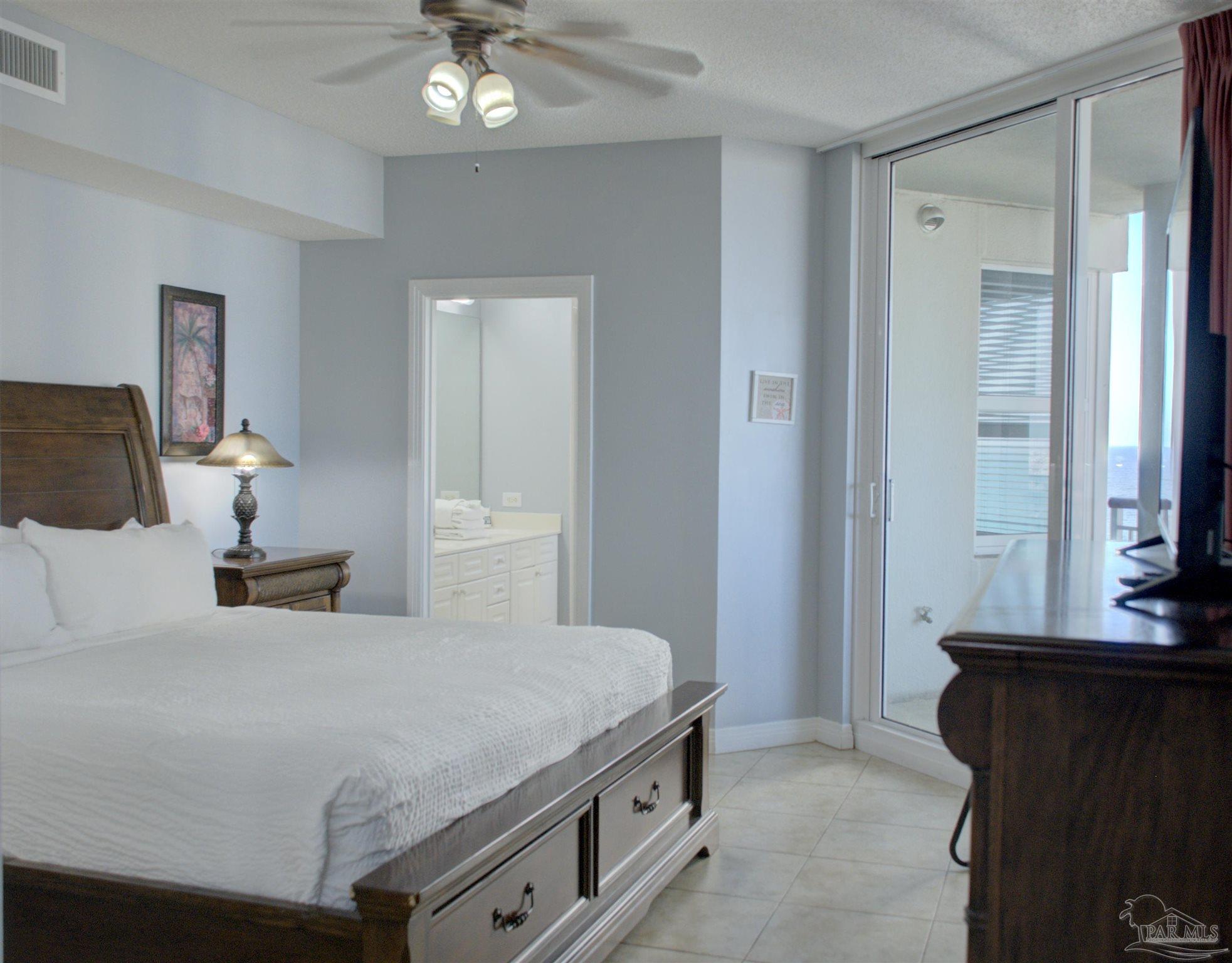 8501 Gulf Boulevard, Unit 10F Navarre, FL 32566 - Photo 17 of 35 a bedroom with a bed and a chandelier