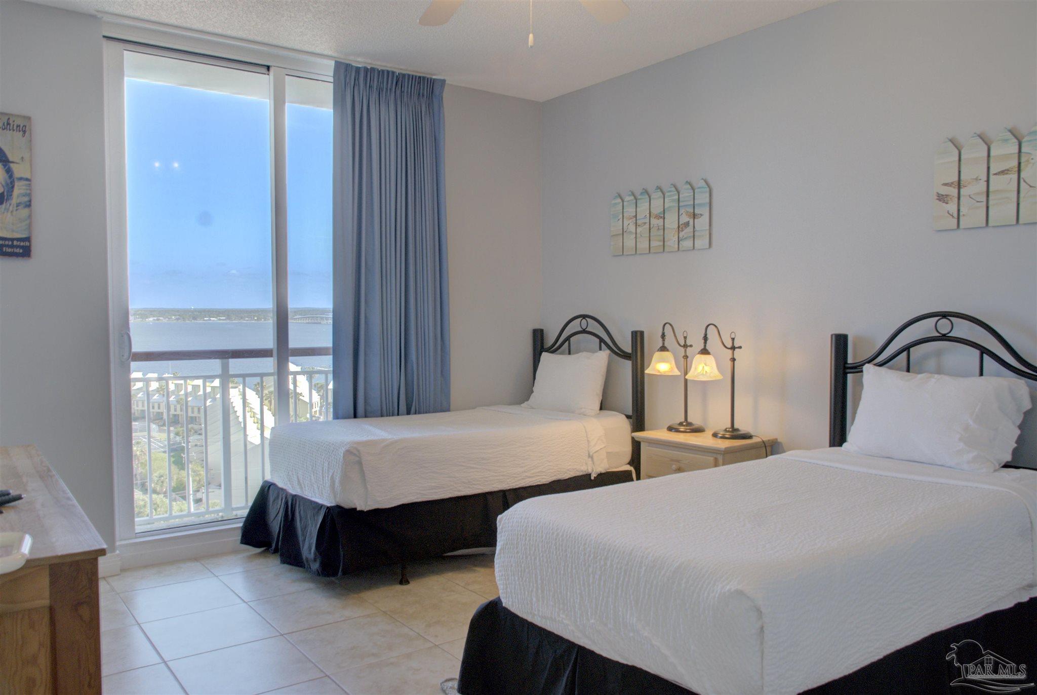 8501 Gulf Boulevard, Unit 10F Navarre, FL 32566 - Photo 21 of 35 a bedroom with two beds and large window