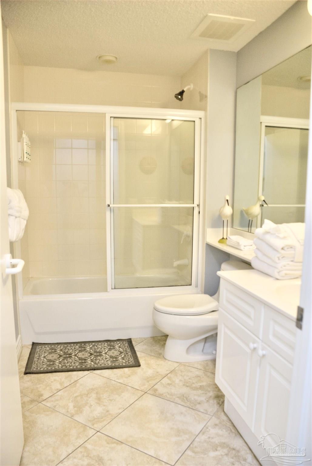 8501 Gulf Boulevard, Unit 10F Navarre, FL 32566 - Photo 23 of 35 a bathroom with a granite countertop sink a toilet and shower