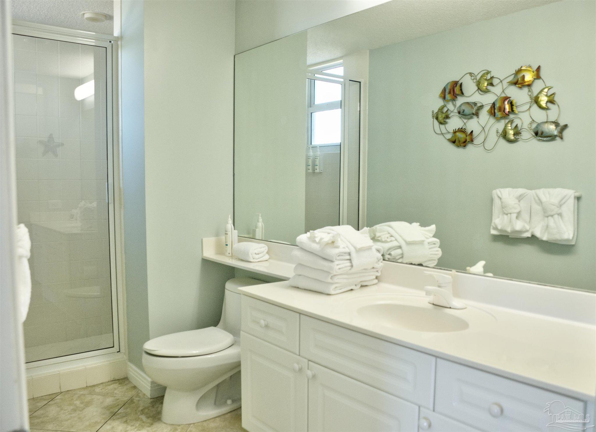 8501 Gulf Boulevard, Unit 10F Navarre, FL 32566 - Photo 26 of 35 a bathroom with a toilet sink and mirror