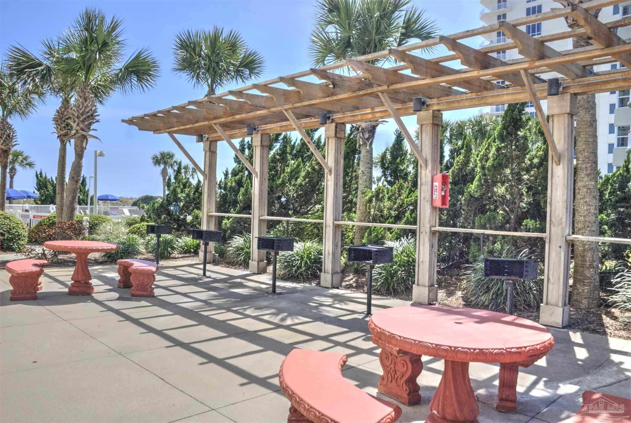 8501 Gulf Boulevard, Unit 10F Navarre, FL 32566 - Photo 29 of 35 a view of a patio with a table chairs and a backyard