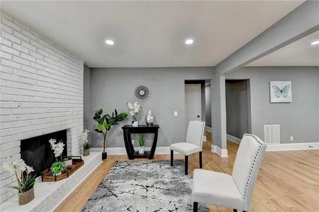 a living room with furniture a fireplace and a potted plant