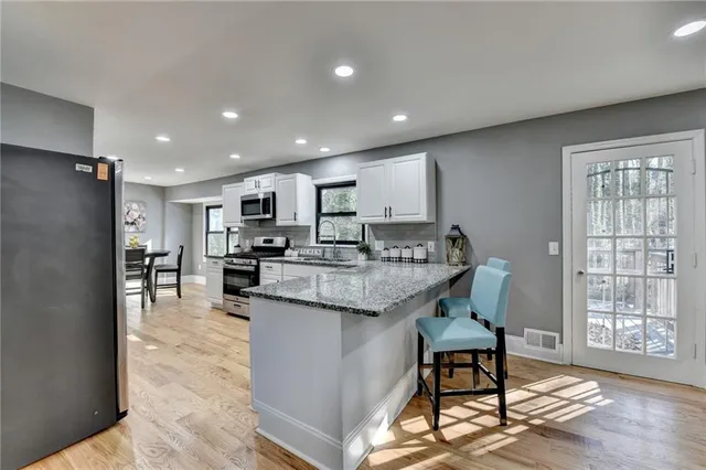 a kitchen with granite countertop white cabinets and white appliances