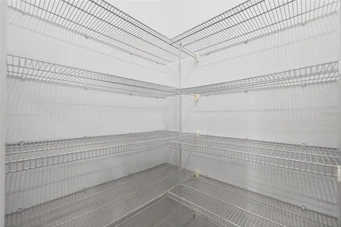 a view of an empty room with a floor to ceiling window and a yard