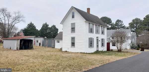 a view of a white house with a yard and garage
