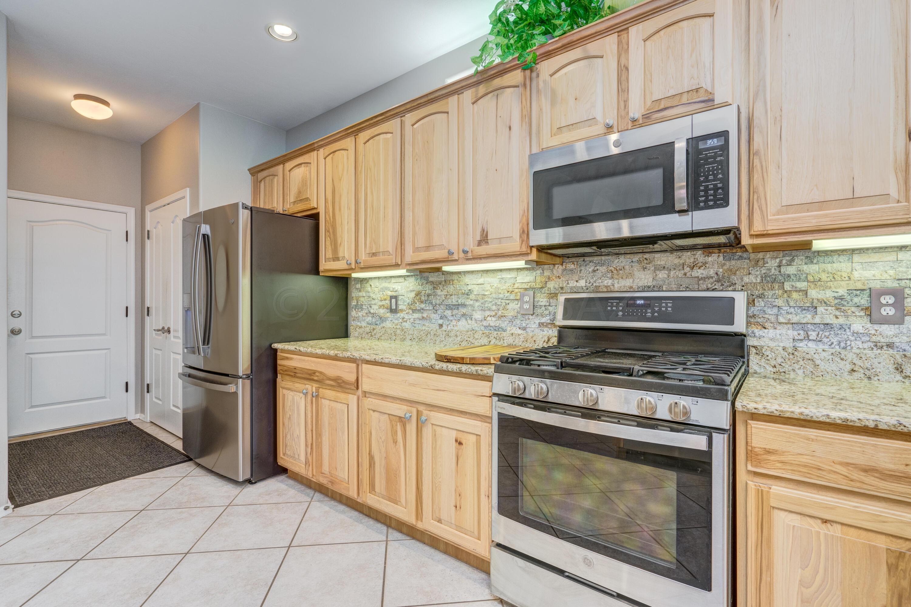 3639 East Northern Dancer Road Tucson, AZ 85739 - Photo 18 of 48 a kitchen with cabinets and steel stainless steel appliances