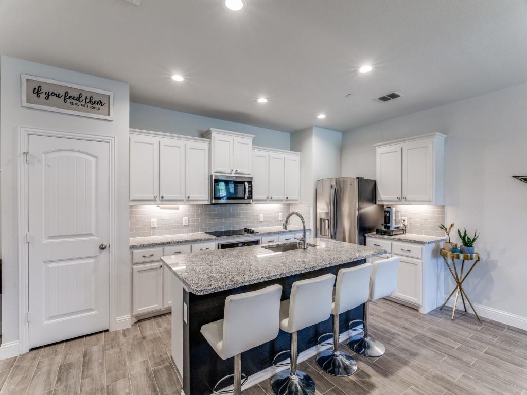 5944 Bursey Road Watauga, TX 76148 - Photo 9 of 25 a kitchen with stainless steel appliances granite countertop a table chairs sink refrigerator and cabinets