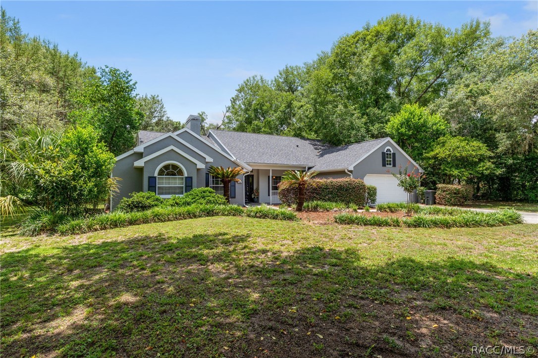 2460 West Pine Ridge Boulevard Beverly Hills, FL 34465 - Photo 2 of 47 a front view of a house with garden