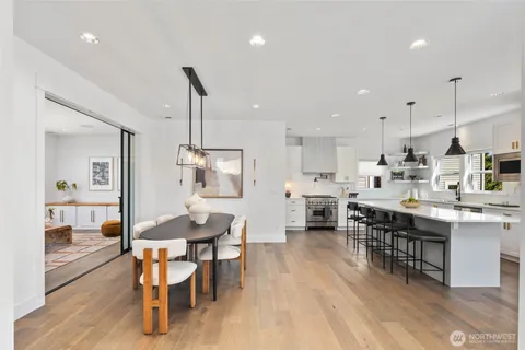 a open dining room with stainless steel appliances kitchen island granite countertop a table chairs and a kitchen view