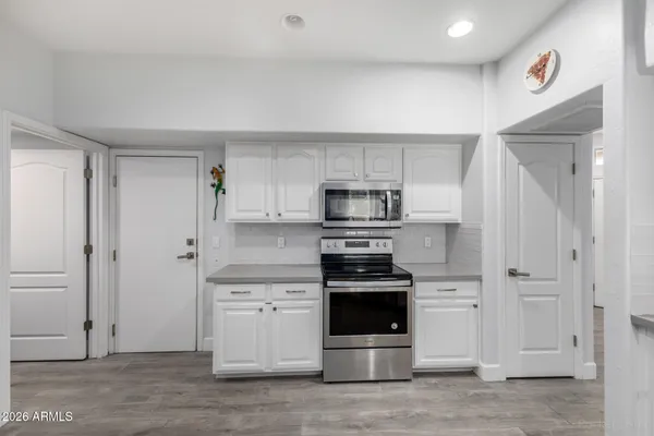 a kitchen with stainless steel appliances white cabinets and a refrigerator