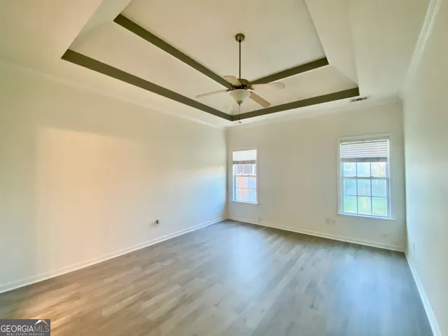 a view of a room with wooden floor and windows