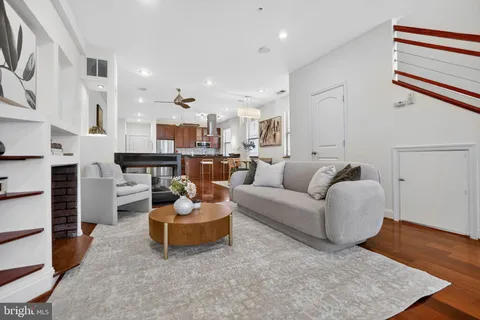 a living room with furniture kitchen view and a fireplace