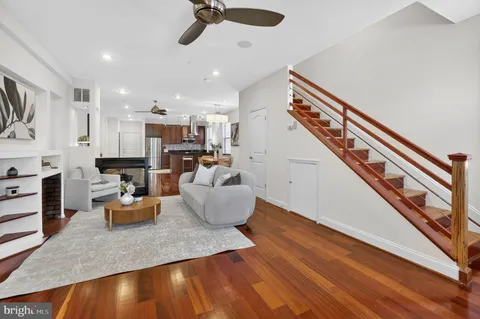 a kitchen with stainless steel appliances granite countertop a refrigerator a sink dishwasher a stove and a refrigerator with wooden floor