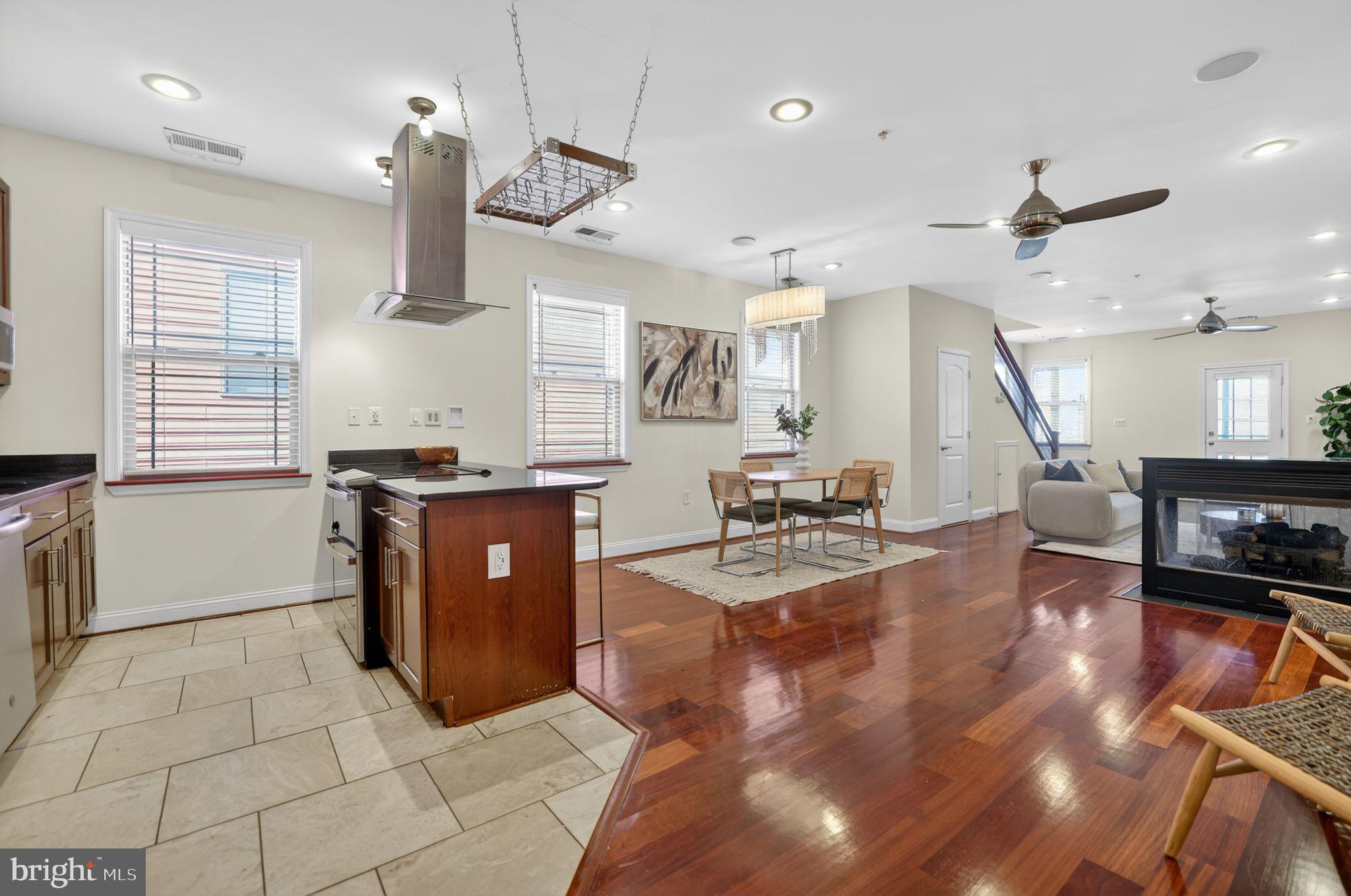 3573 Warder Street Northwest, Unit 7 Washington, DC 20010 - Photo 14 of 61 a kitchen with stainless steel appliances kitchen island granite countertop a stove a sink a dining table and chairs with wooden floor