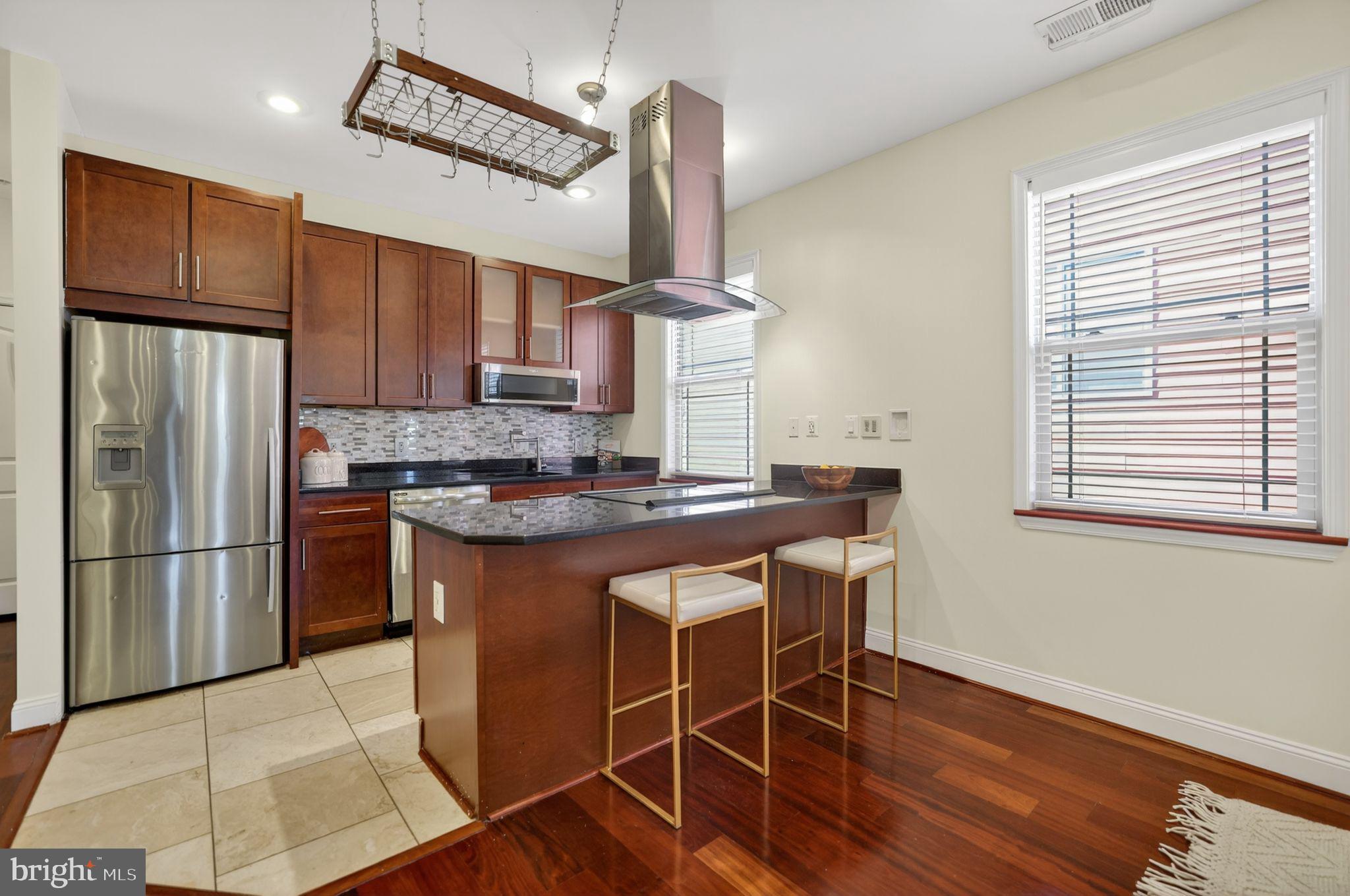 3573 Warder Street Northwest, Unit 7 Washington, DC 20010 - Photo 17 of 61 a kitchen with stainless steel appliances granite countertop a refrigerator a sink dishwasher a stove and a refrigerator with wooden floor