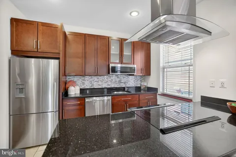 a kitchen with stainless steel appliances granite countertop a refrigerator and a stove