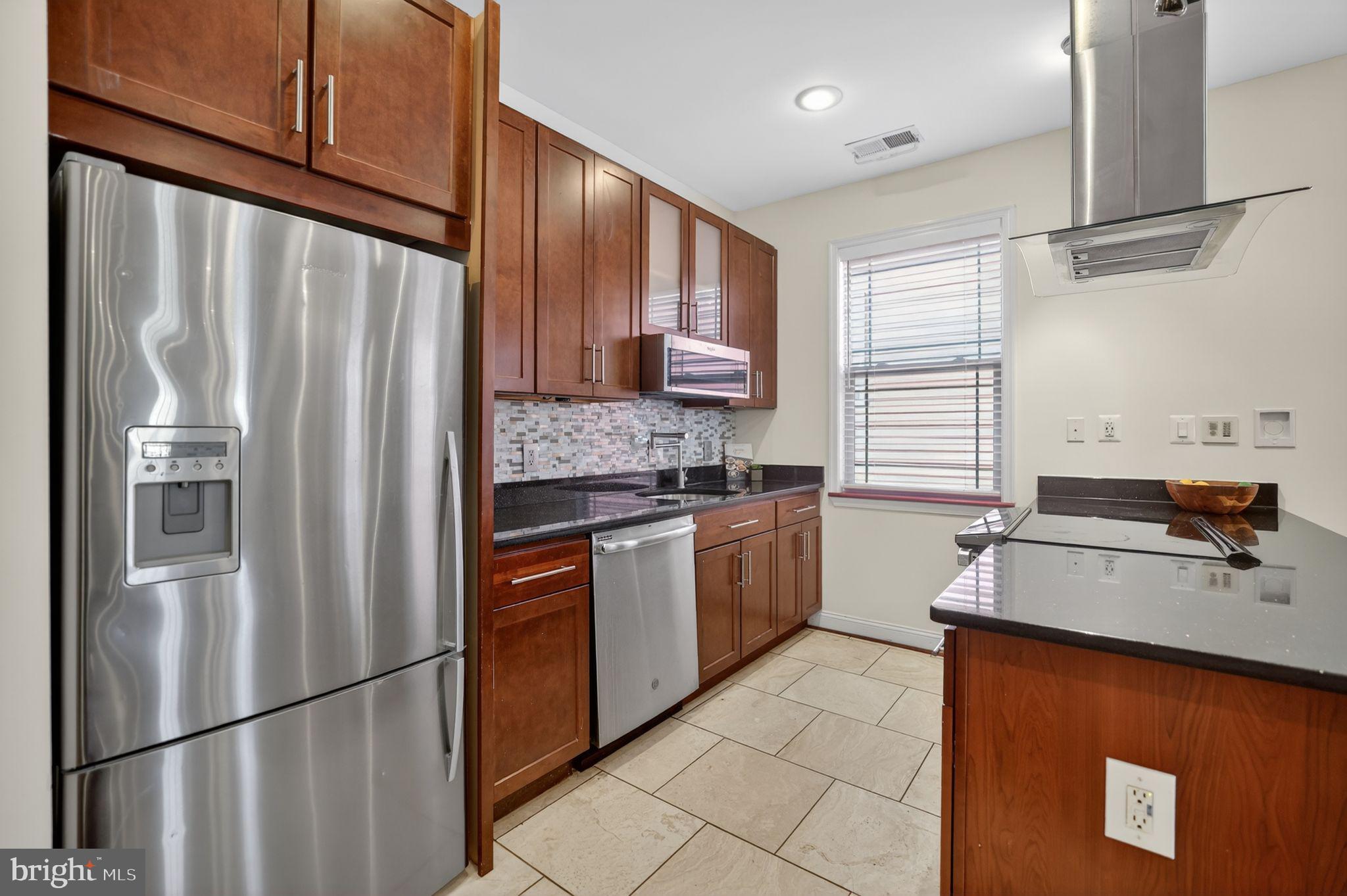 3573 Warder Street Northwest, Unit 7 Washington, DC 20010 - Photo 20 of 61 a kitchen with stainless steel appliances granite countertop a refrigerator and a sink
