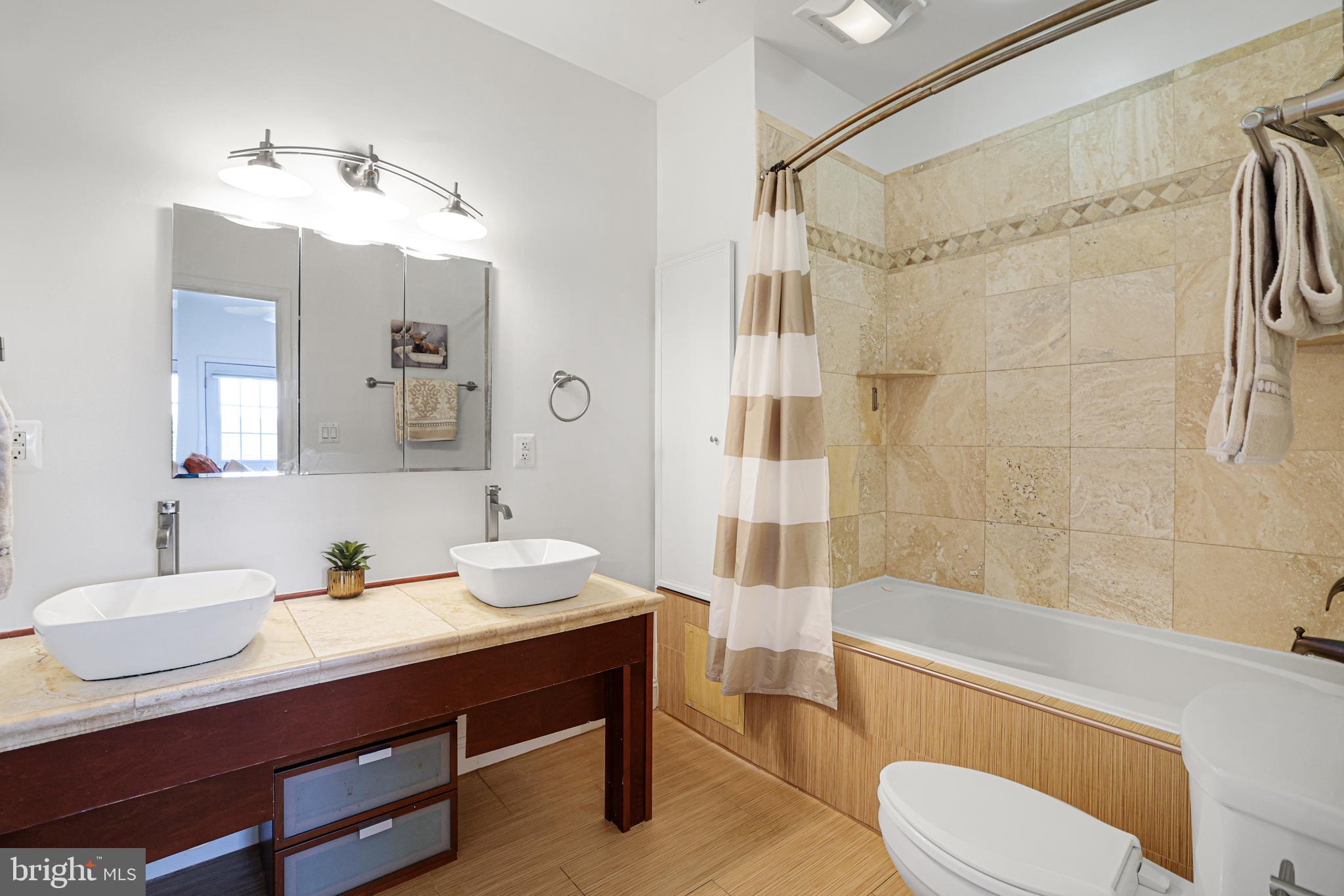 3573 Warder Street Northwest, Unit 7 Washington, DC 20010 - Photo 34 of 61 a bathroom with a sink a toilet a mirror a bathtub and shower