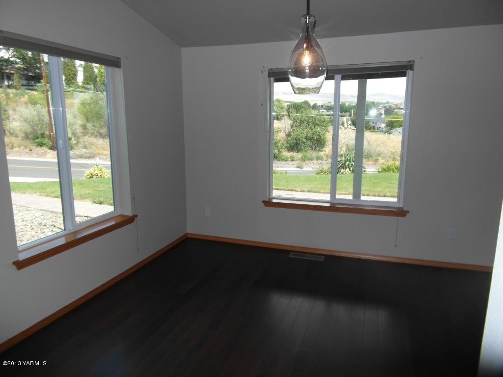 508 Canyon Road Yakima, WA 98901 - Photo 7 of 31 a view of an empty room with wooden floor and a window